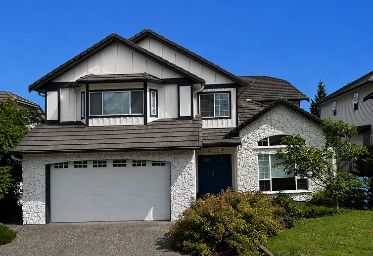 Freshly painted white and dark trim stucco house exterior by ColorWorks Painting Calgary