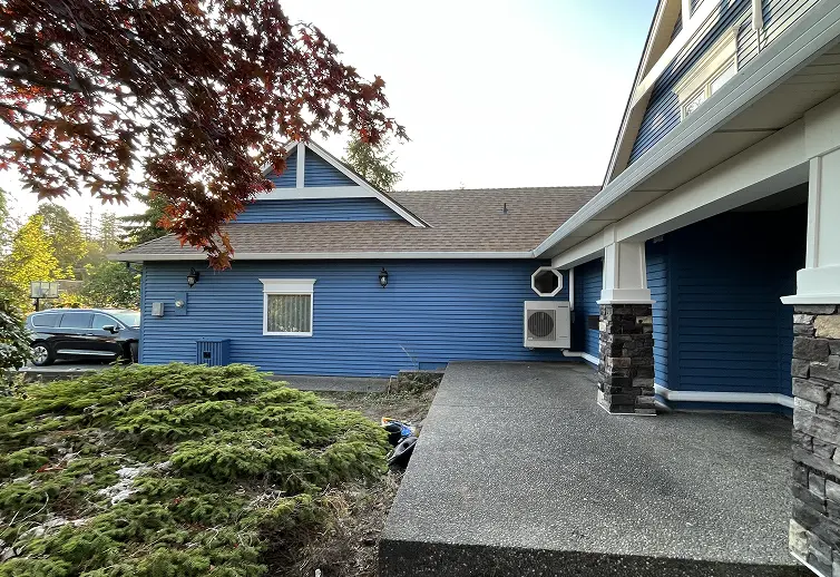 Completed modern exterior siding painting project featuring newly refreshed blue garage trim accents