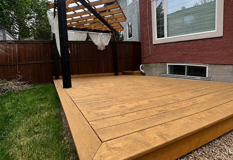 After professional deck staining in Calgary showcasing a freshly sealed, bright honey-gold wood deck.