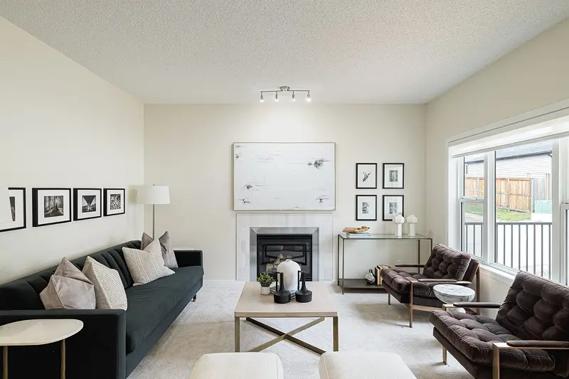 Modern living room interior painting by Color Works Painting featuring crisp white walls, a black accent sofa, and a clean white fireplace mantel.