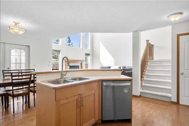 Open-concept kitchen and staircase wall painting by Color Works Painting, emphasizing clean lines and bright, light-reflecting wall finishes.