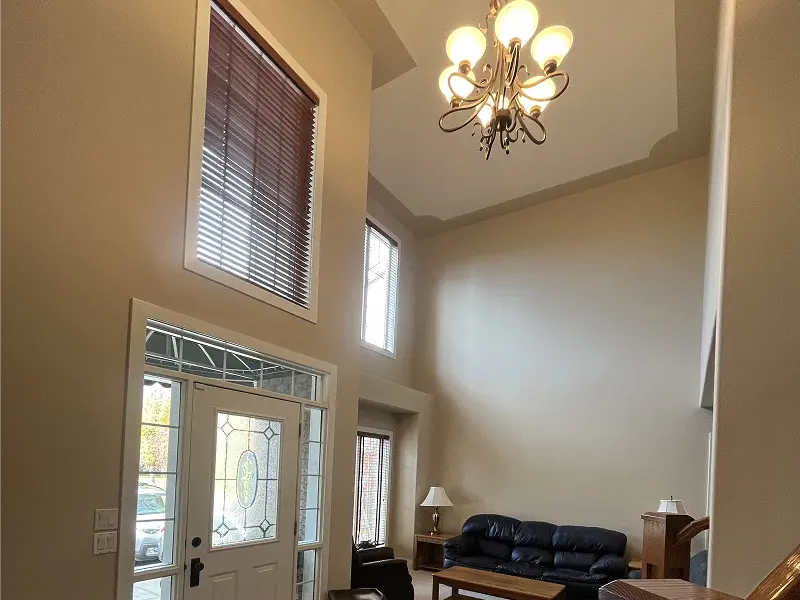 Professional interior painting in Calgary home featuring a bright two-story foyer with modern neutral walls and natural light.