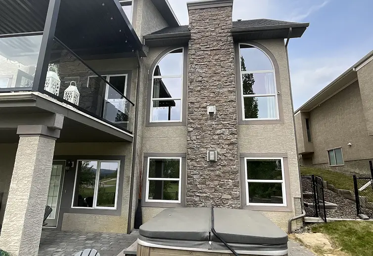 Exterior stucco wall surface before painting showing worn and unpainted finish on residential building