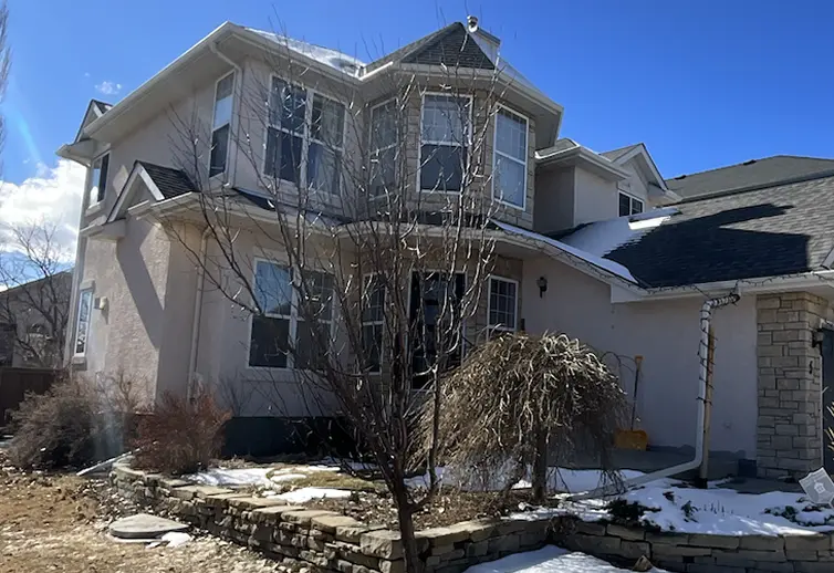 Before stucco painting preparation stage with rough, faded stucco exterior wall texture